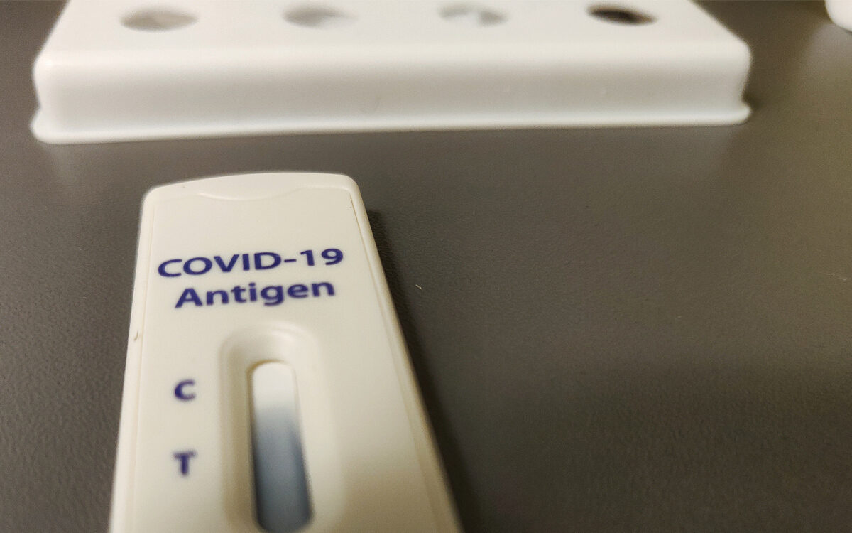 Ein Antigen Schnelltest auf Corona mit der Aufschrift Covid-19 mit Teststreifen der sich bläulich färbt Ein Antigen Schnelltest auf Corona mit der Aufschrift Covid-19 mit Teststreifen der sich bläulich färbt